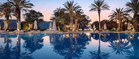 Una piscina al aire libre de temporada, sombrillas