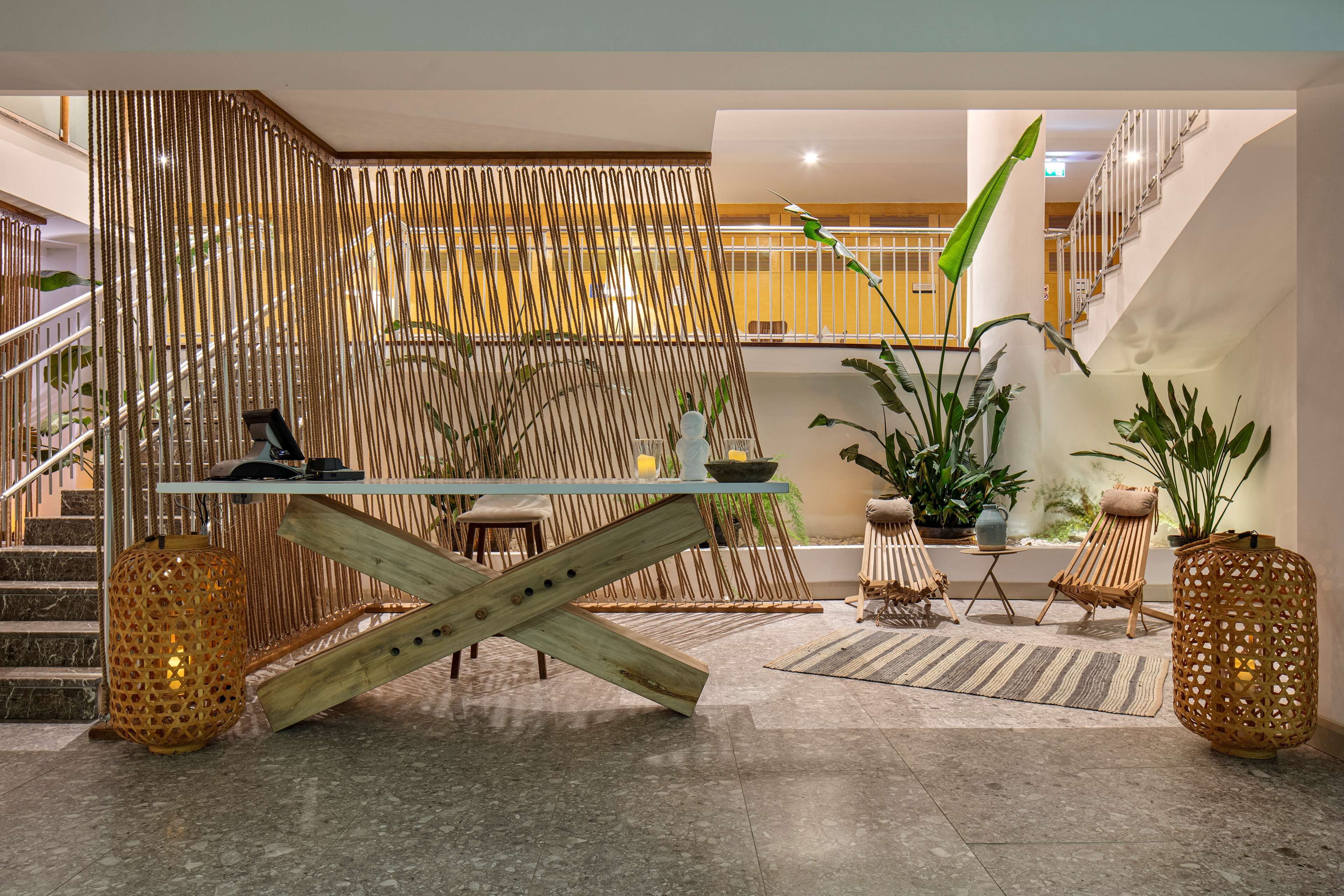 Un interior moderno con una escalera, una mesa de madera y una zona de estar.