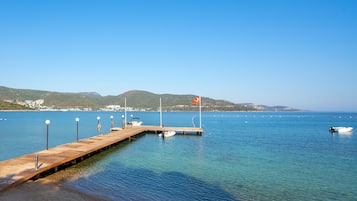 Praia particular, espreguiçadeiras, guarda-sóis, toalhas de praia