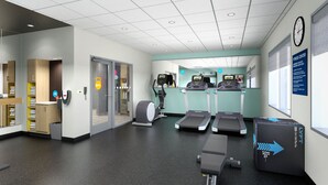 Un gimnasio con cintas de correr, elíptica y banco de pesas.