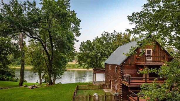 A log cabin with a deck and a view of a lake. - SECLUDED WHITE RIVERFRONT CABIN -SLEEPS 2-10, GREAT FAMILY & FISHERMEN GETAWAY (Norfork)