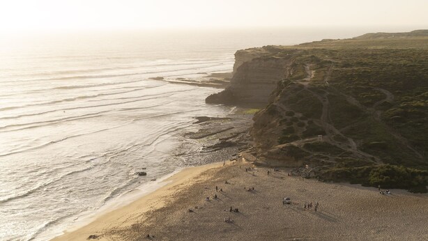 A coastal beach with a rocky cliff and a path leading up to it. - Ericeira Paradise House & Suites (Mafra)