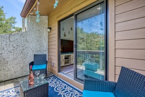 Relax on the balcony with a wicker chair and enjoy a refreshing drink from the small table.