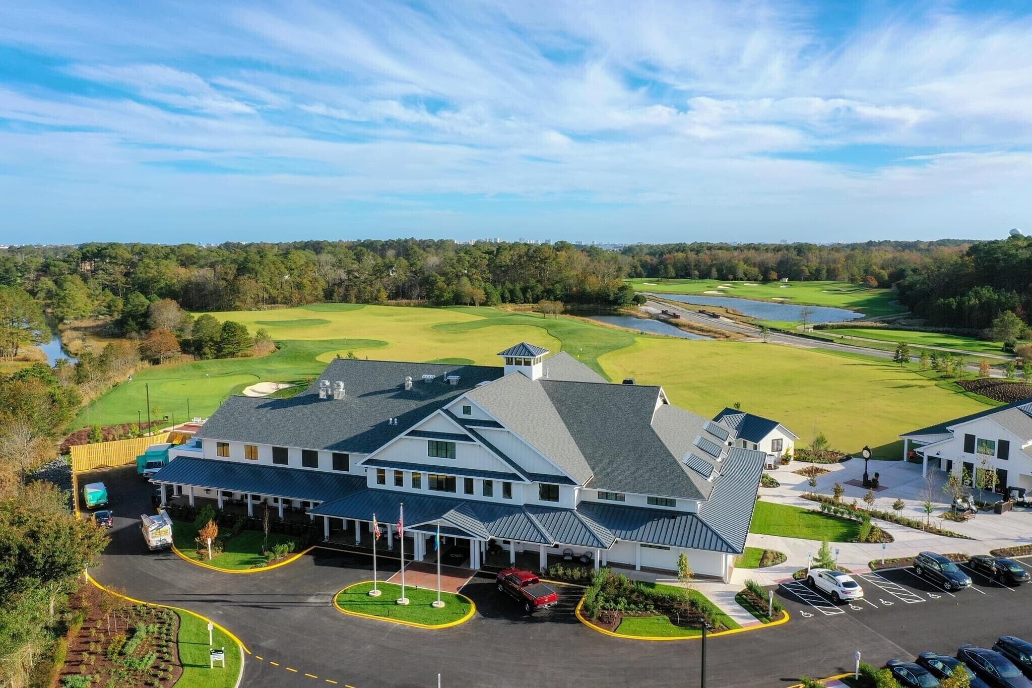 A golf course with a clubhouse and parking area.