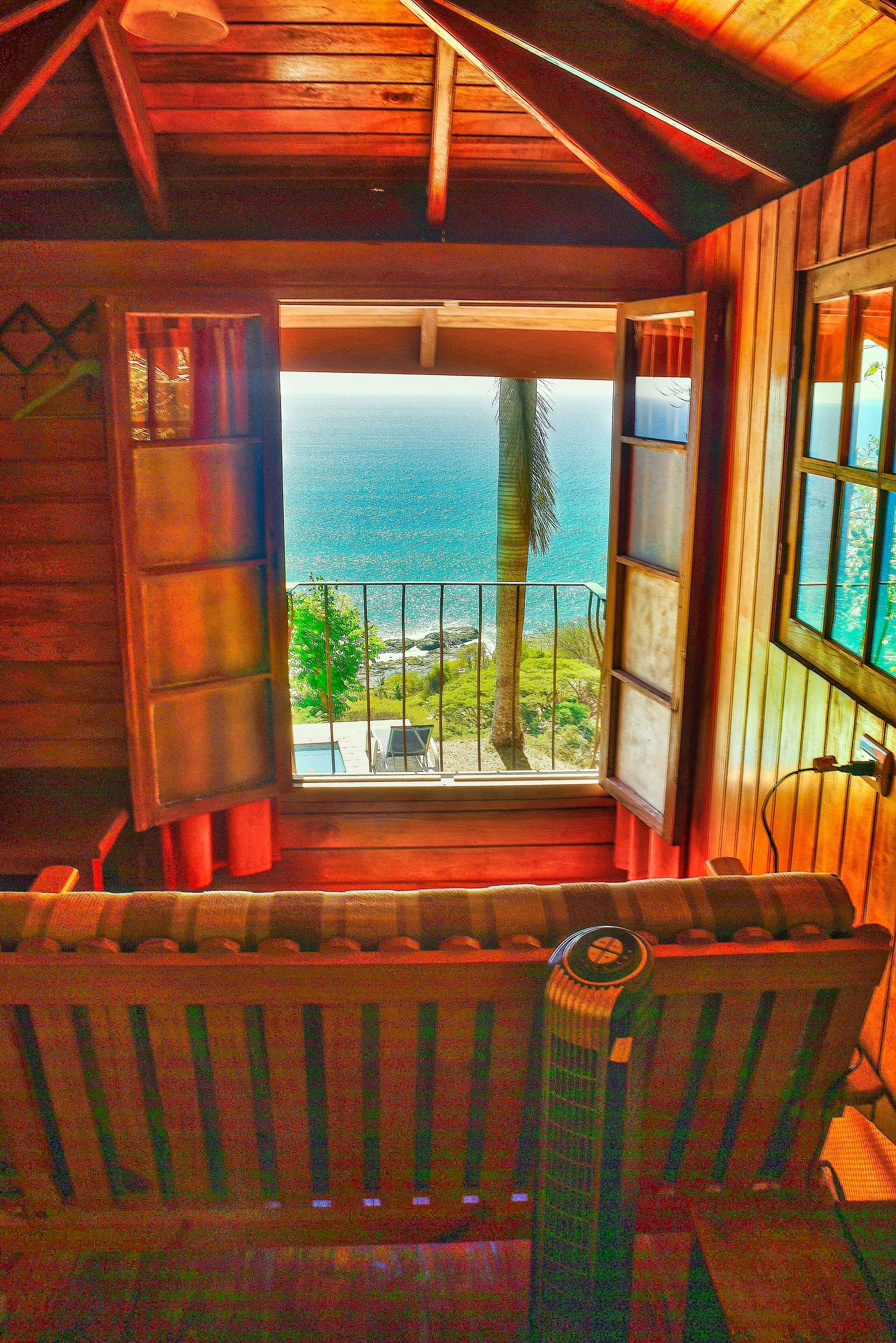Uma cabana de madeira com varanda com vista para o oceano.