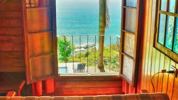 Uma cabana de madeira com varanda com vista para o oceano.