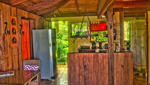 Una cocina rústica con paredes de madera, un refrigerador y una encimera con varios objetos.