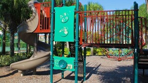 A playground with a slide, climbing structures, and a fenced area.