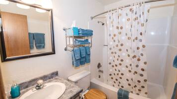 A bathroom with a sink, toilet, and shower.
