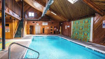 An indoor swimming pool with wooden walls and a tiled floor.