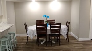 A dining area with a round table, four chairs, and a potted plant. - Spacious Suite: Basement Apartment (Enoch)