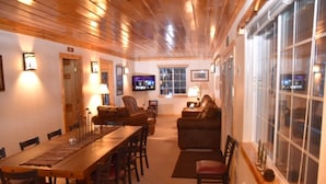 A cozy room with a wooden ceiling, a dining table with chairs, a sofa, and a television. - Eagle's Landing, is located in Island Park, ID, 35 miles from West Yellowstone (Island Park)