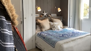 Een slaapkamer met een bed, een zeester decoratie en een lamp.