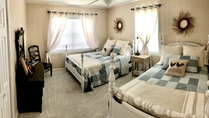 A bedroom with two beds, a nightstand, a lamp, and a mirror.