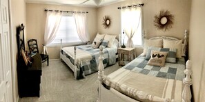 Two single beds with matching headboards and footboards, a nightstand, and a dresser create a functional and comfortable space.