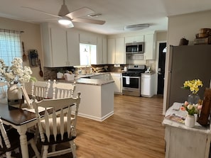 Enjoy cooking in this well-equipped kitchen with a central island, stove, oven, and refrigerator.