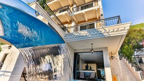 A hotel with a swimming pool, a waterfall feature, and a balcony with outdoor seating. - Hotel Tate by Aycon (Budva)