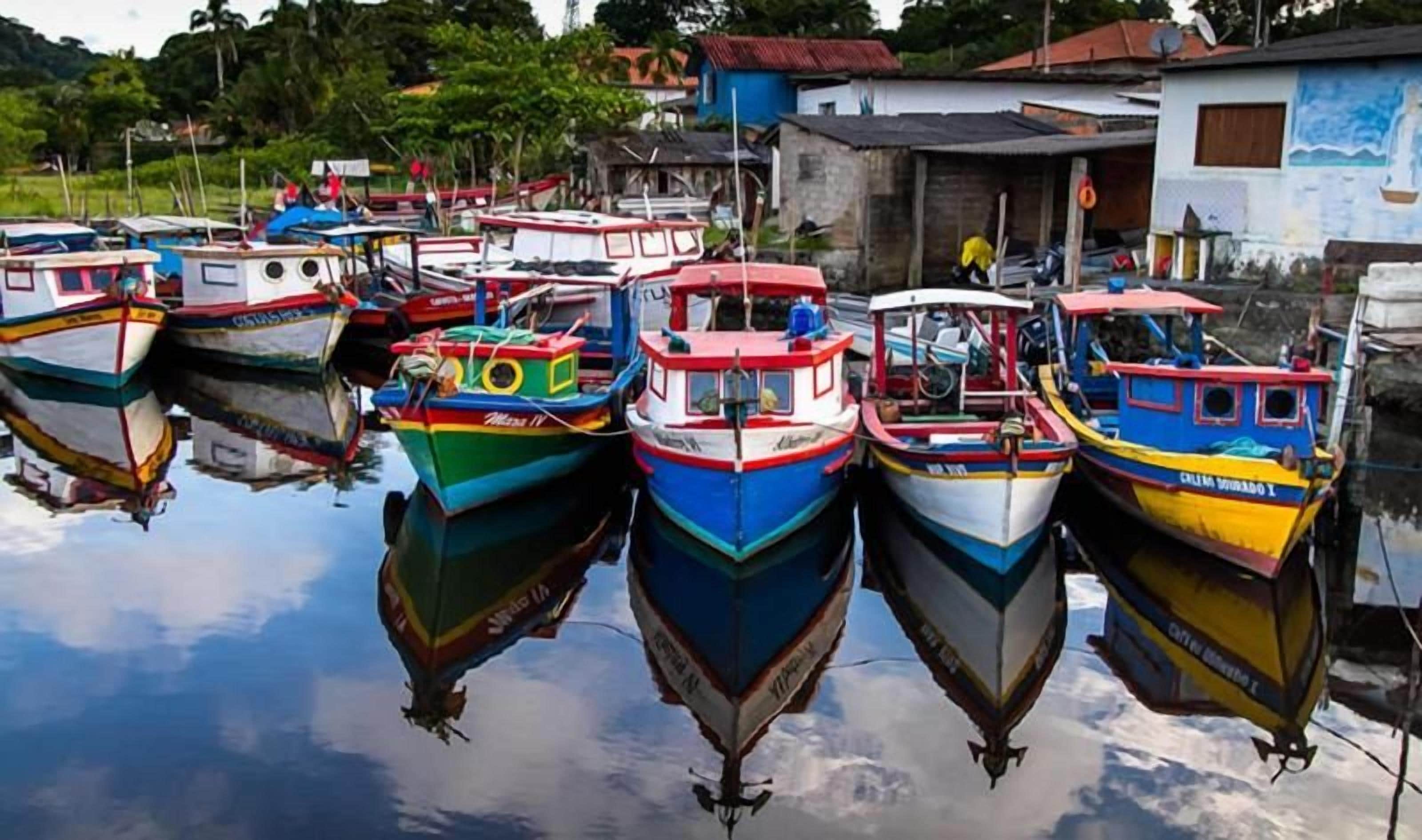 Marina com vários barcos atracados em águas calmas, cercada por edifícios.