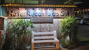Ein Hotel Eingang mit einem Schild, das "Hotel Recanto do Sol" zeigt, und einer Rezeption.