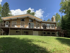 Une maison à deux étages avec une terrasse en bois et un garage.