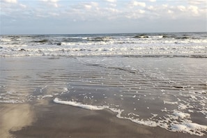 A beach with waves approaching the shore.