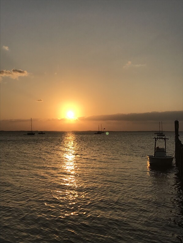 A sunset over a calm sea with boats and a dock. - Stay in Paradise (Key Largo)