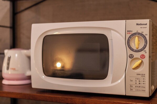 En hvid mikrobølgeovn med digitalt display og to knapper på højre side.