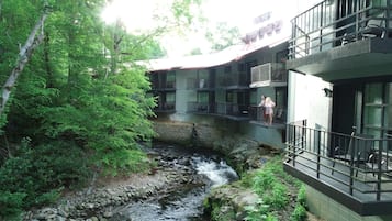 A building with multiple balconies overlooking a stream.