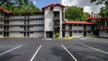 A multi-story motel with a central tower, a parking lot, and a sign indicating it is the Bear Creek Inn.