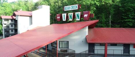 Een gebouw met een rood dak en een bord waarop staat 'Bear Creek Inn'.