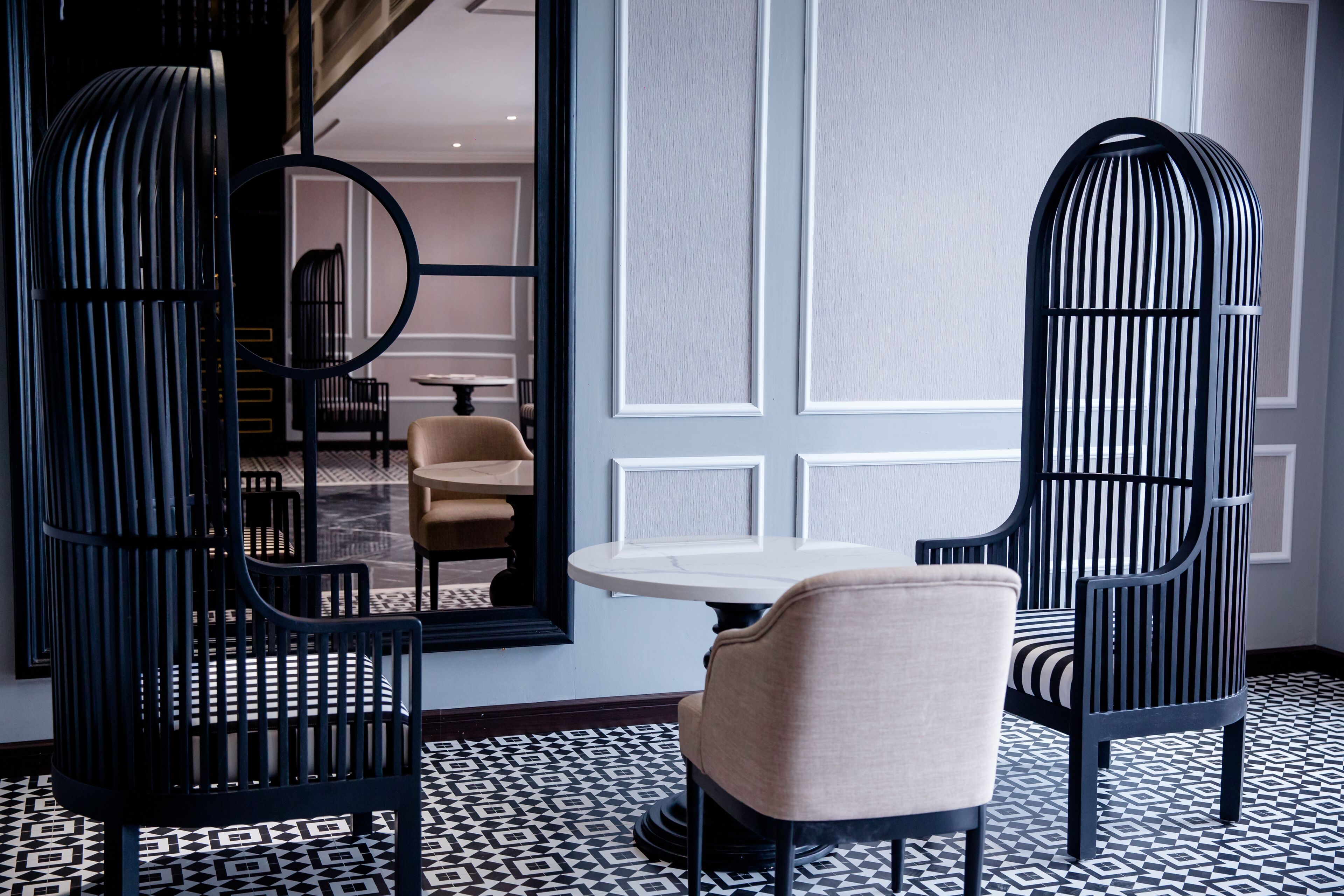 A modern interior with a round table and two chairs, one with a striped pattern.