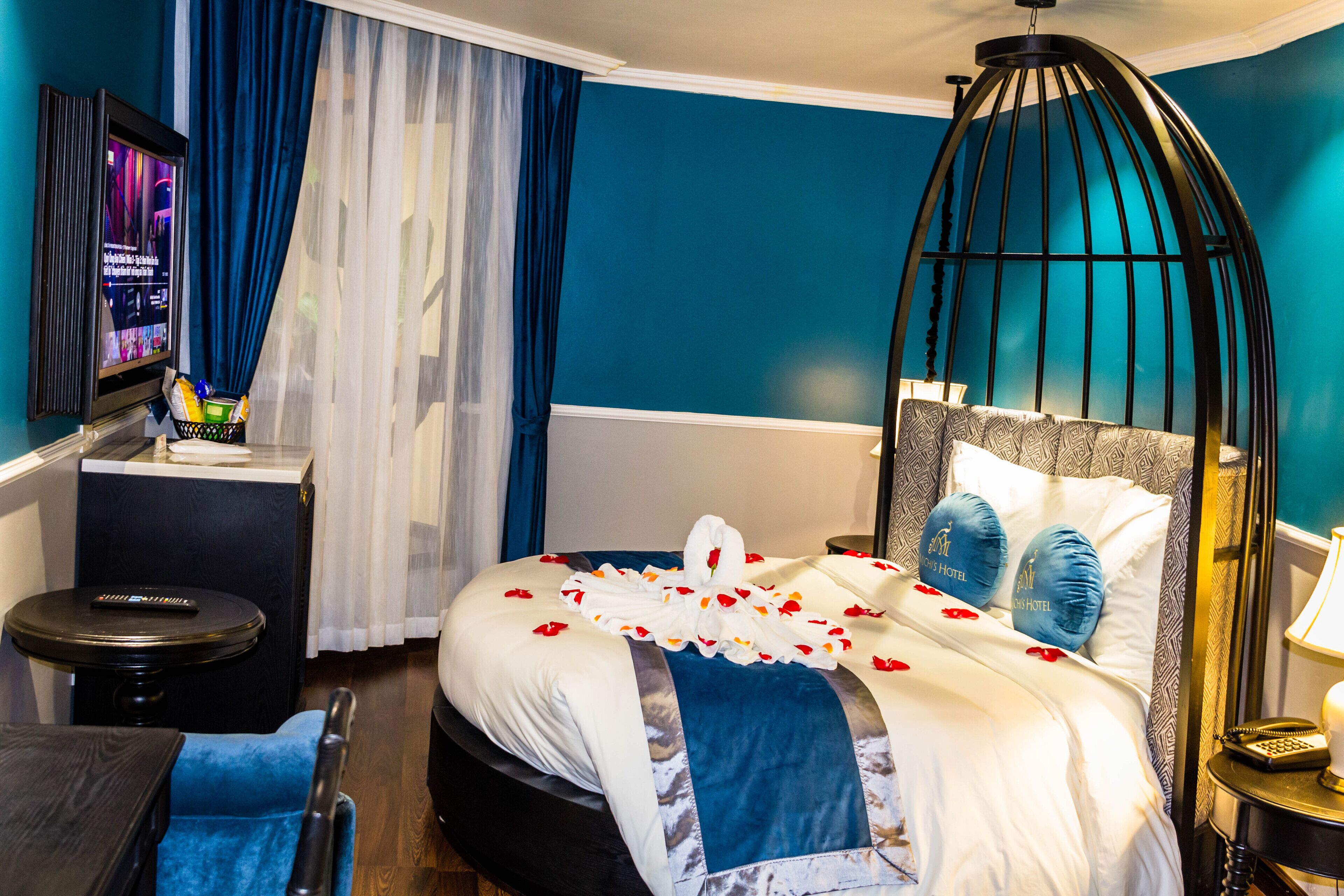 A hotel room with a bed, a TV, a desk, and a chair.