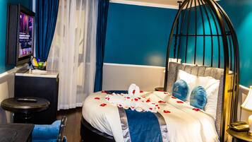 A hotel room with a bed, a TV, a desk, and a chair.