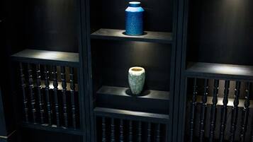 A dark wooden shelving unit with various objects displayed on multiple shelves.