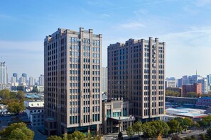 Two tall hotel buildings with a modern design, featuring a prominent entrance and a clear view of the surrounding cityscape. - Courtyard by Marriott Taiyuan (Taiyuan)