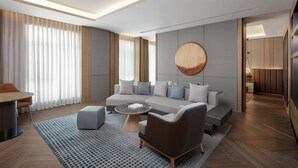 Ein modernes Wohnzimmer mit einer Eckcouch, einem runden Couchtisch und einem Essbereich mit Tisch und Stühlen.