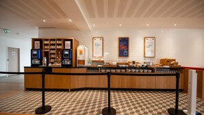 A reception area with a check-in counter, a self-service kiosk, and a display of amenities. - Holiday Inn Express Arcachon - La Teste by IHG (La Teste-de-Buch)