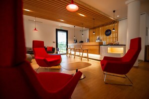 Experience a warm and inviting atmosphere in our lobby, featuring a comfortable seating area and a welcoming reception desk.