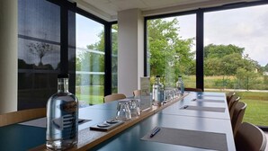 A conference room with a long table, chairs, a bottle of liquor, glasses, and a sign labeled "RESERVE". - Holiday Inn Express Arcachon - La Teste by IHG (La Teste-de-Buch)