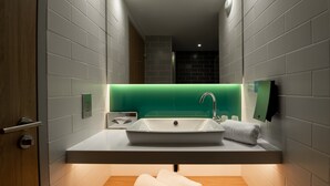 A modern bathroom with a large sink, a mirror, and a green accent wall. - Holiday Inn Express Arcachon - La Teste by IHG (La Teste-de-Buch)