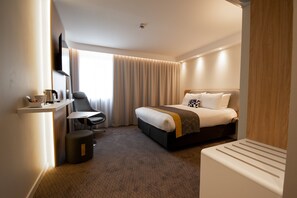 A hotel room with a bed, a desk, a chair, and a small ottoman. - Holiday Inn Express Arcachon - La Teste by IHG (La Teste-de-Buch)