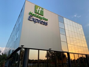 Welcome to Holiday Inn Express, featuring a modern architectural design with a glass facade.