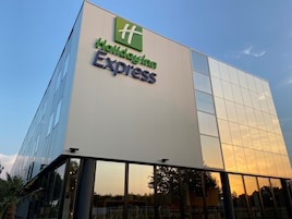 Un edificio moderno con fachada de vidrio y un letrero que dice "Holiday Inn Express".