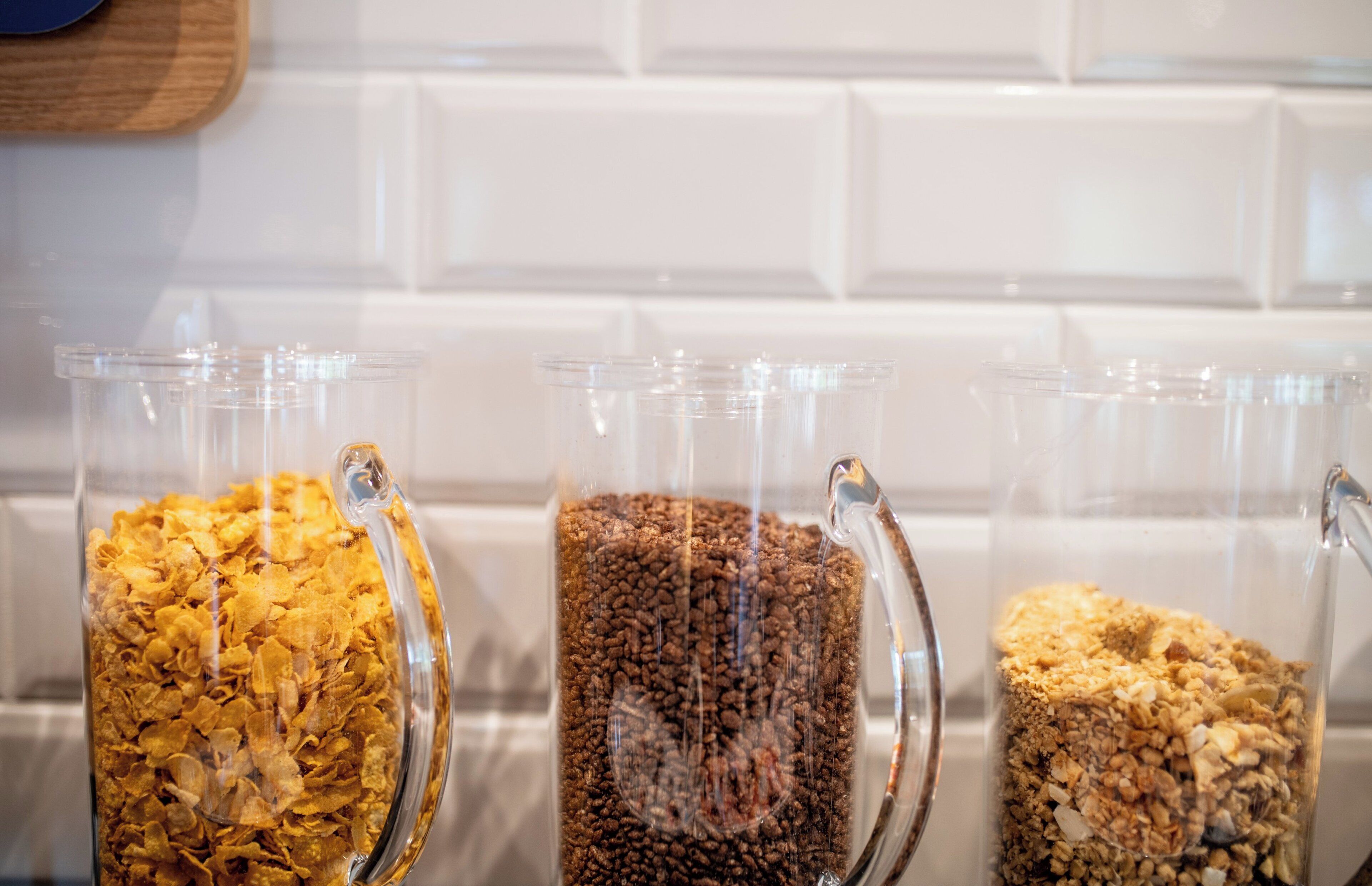 Three glass containers with different food items on a kitchen counter.