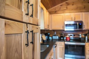Una cocina con armarios de madera y un microondas.