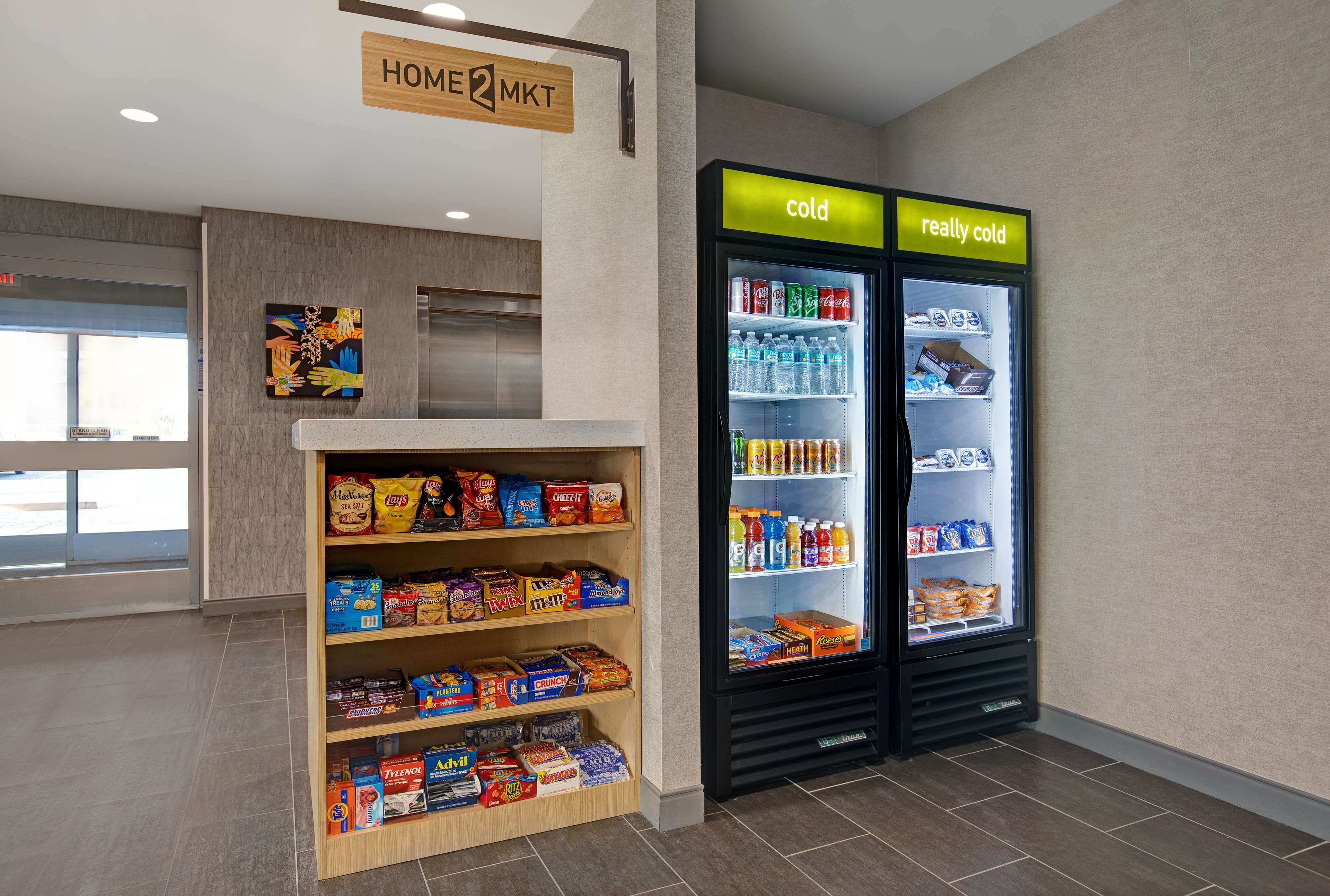 A snack display and two refrigerators labeled "cold" and "really cold" in a hotel lobby.