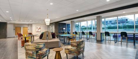 A spacious indoor area with a mix of seating options, including sofas and chairs, and a large table.