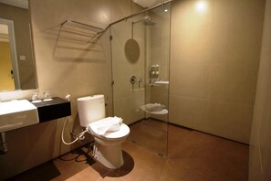 A modern bathroom with a glass-enclosed shower, a toilet, and a sink. - Vinotel Cirebon (West Cirebon)