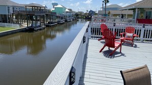 Una terrazza sul lungomare con poltrone Adirondack rosse e un parapetto bianco.