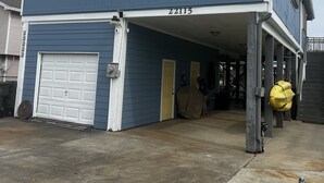 Una casa a due piani con un garage, un portico coperto e il numero 22115 sulla facciata.